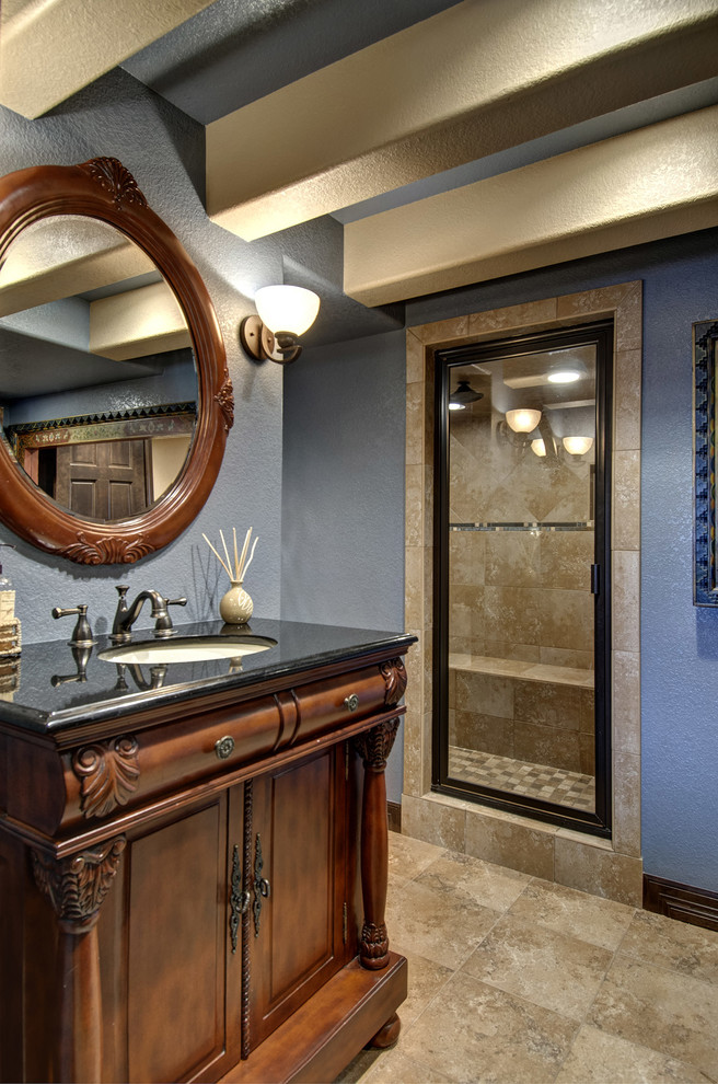 Alcove shower - small traditional beige tile and porcelain tile porcelain tile and beige floor alcove shower idea in Denver with furniture-like cabinets, medium tone wood cabinets, a two-piece toilet, blue walls, an undermount sink, granite countertops, a hinged shower door and black countertops
