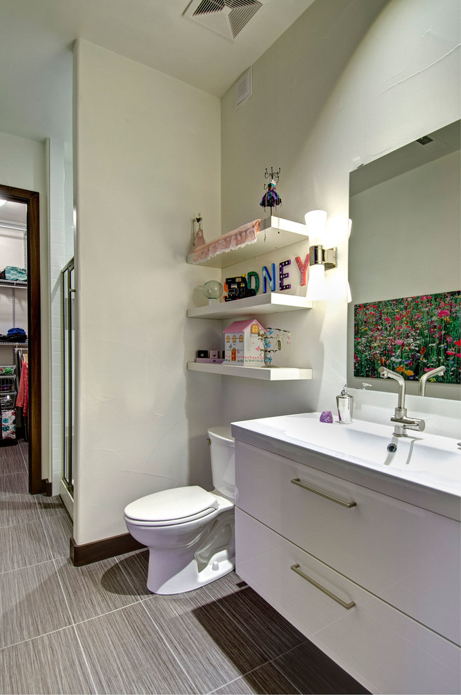 Idéer för att renovera ett mellanstort funkis vit vitt badrum med dusch, med släta luckor, vita skåp, en dusch i en alkov, en toalettstol med separat cisternkåpa, vita väggar, klinkergolv i porslin, ett integrerad handfat, bänkskiva i kvarts, grått golv och dusch med gångjärnsdörr