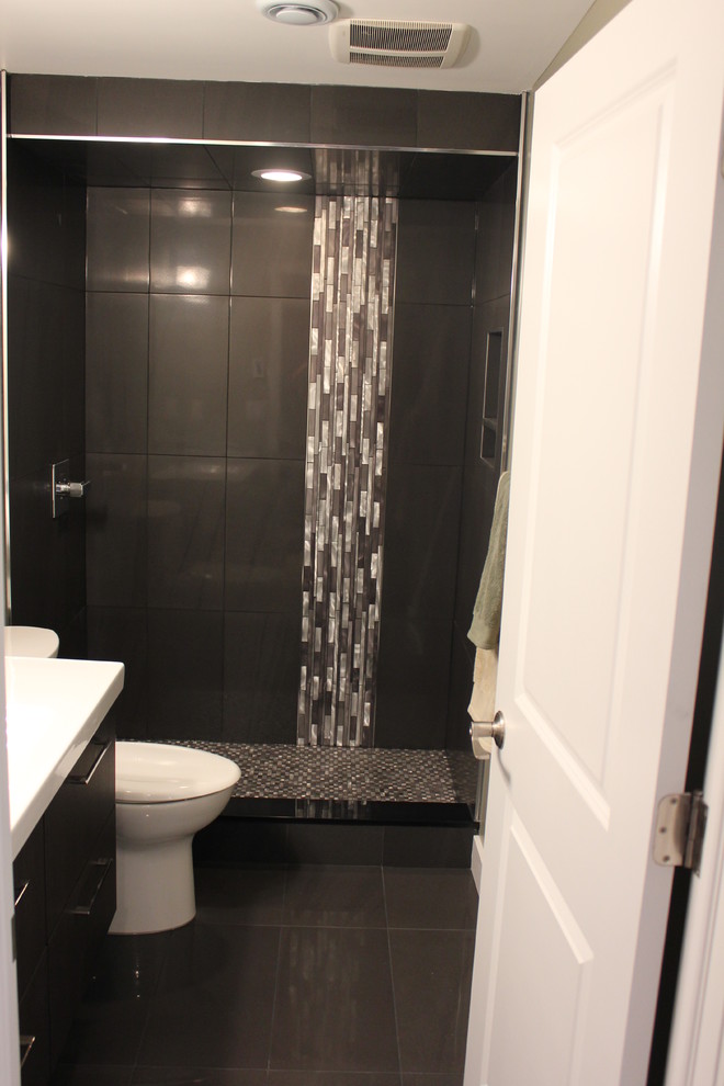 Inspiration for a medium sized modern shower room bathroom in Calgary with flat-panel cabinets, dark wood cabinets, an alcove shower, a two-piece toilet, beige tiles, brown tiles, mosaic tiles, beige walls, vinyl flooring, an integrated sink and solid surface worktops.