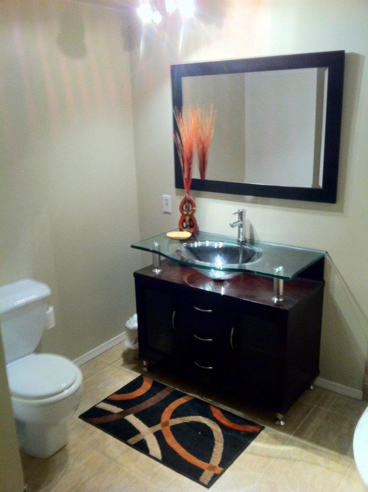 Foto di una piccola stanza da bagno contemporanea con ante in legno bruno, top in vetro, doccia ad angolo, piastrelle beige, piastrelle in ceramica, pareti beige e pavimento con piastrelle in ceramica