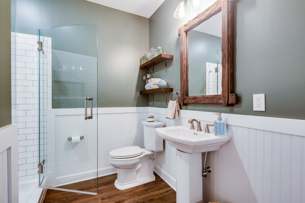 Пример оригинального дизайна: ванная комната среднего размера в стиле неоклассика (современная классика) с раздельным унитазом, белой плиткой, керамической плиткой, серыми стенами, раковиной с пьедесталом, коричневым полом и душем с распашными дверями