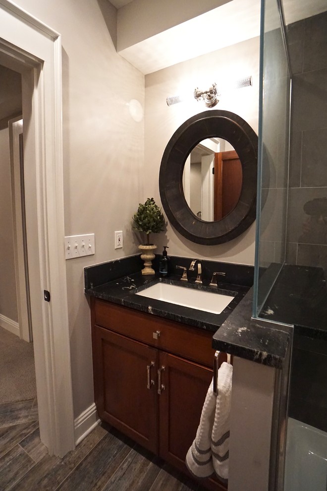 Esempio di una piccola stanza da bagno padronale design con consolle stile comò, ante in legno bruno, doccia ad angolo, piastrelle grigie, lavabo sottopiano, pavimento multicolore e top nero
