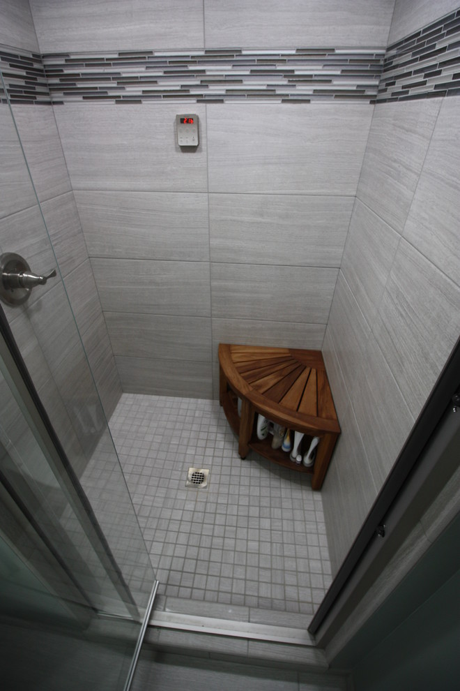 Cette photo montre un petit sauna moderne en bois brun avec un lavabo intégré, un placard avec porte à panneau surélevé, un plan de toilette en marbre, WC séparés, un carrelage gris, des carreaux de porcelaine, un mur gris et un sol en carrelage de porcelaine.