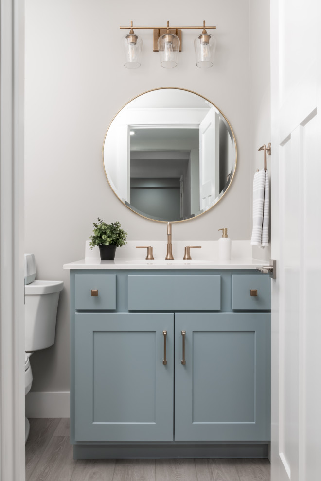 Idéer för små vintage vitt badrum, med släta luckor, blå skåp, en toalettstol med separat cisternkåpa, grå väggar, ett integrerad handfat, bänkskiva i akrylsten och grått golv