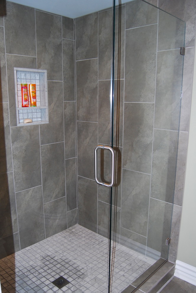 Réalisation d'une salle de bain tradition de taille moyenne avec un plan de toilette en marbre et un carrelage gris.