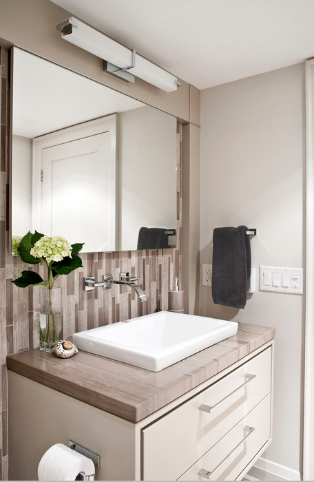 Свежая идея для дизайна: ванная комната в современном стиле с подвесной раковиной, плоскими фасадами, мраморной столешницей, керамогранитной плиткой, бежевыми стенами и полом из керамогранита - отличное фото интерьера