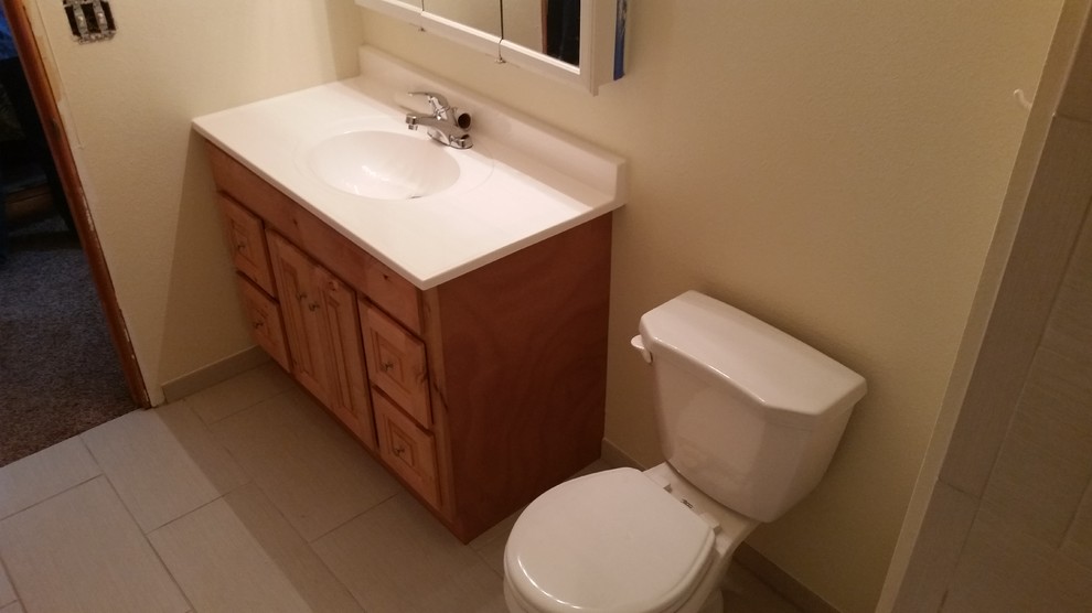 Exempel på ett mellanstort klassiskt badrum med dusch, med luckor med upphöjd panel, skåp i ljust trä, beige kakel, keramikplattor, bänkskiva i kalksten, ett badkar i en alkov, en dusch/badkar-kombination, en toalettstol med separat cisternkåpa, beige väggar, laminatgolv, ett integrerad handfat, beiget golv och dusch med duschdraperi
