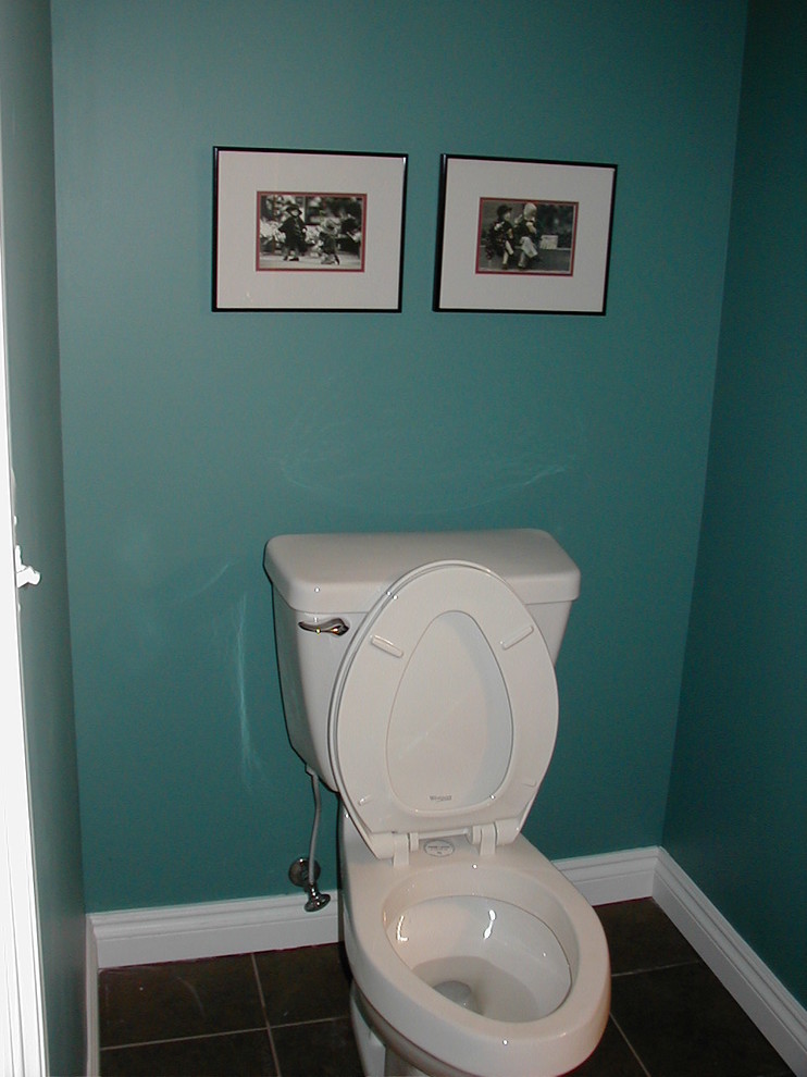 Cette photo montre un WC et toilettes chic de taille moyenne avec un placard avec porte à panneau surélevé, des portes de placard blanches, WC séparés, un carrelage marron, des carreaux de céramique, un mur vert, un sol en carrelage de céramique, un lavabo de ferme et un plan de toilette en surface solide.
