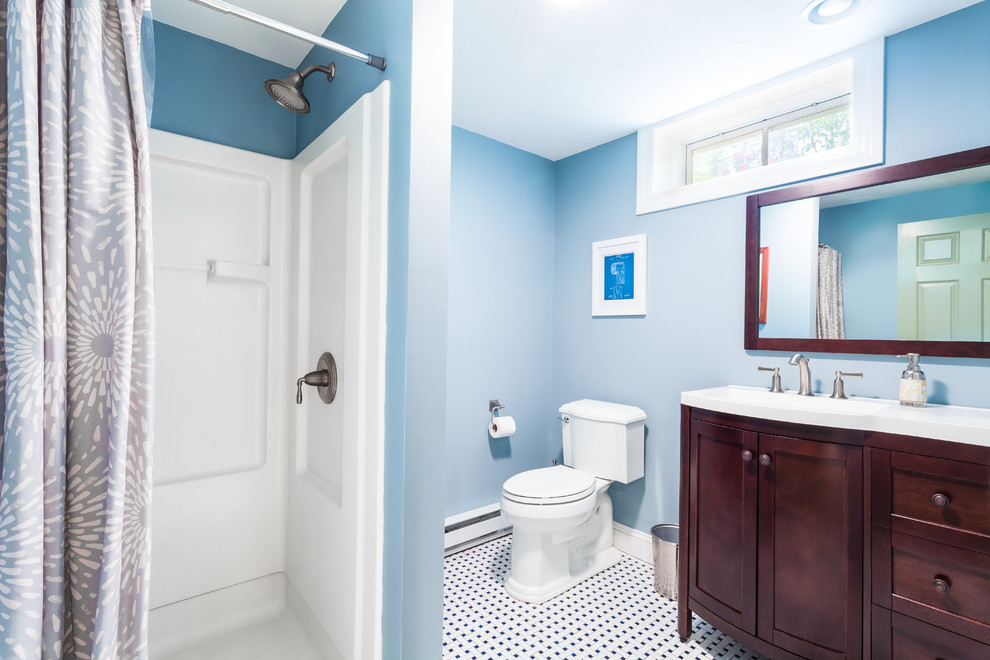 Cette photo montre une petite salle de bain chic en bois foncé avec WC séparés, un carrelage noir et blanc, un mur bleu, un sol en carrelage de céramique, un lavabo intégré, un placard avec porte à panneau encastré, des carreaux de céramique et un plan de toilette en surface solide.