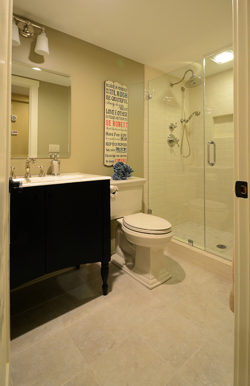 Idéer för mellanstora vintage badrum med dusch, med släta luckor, svarta skåp, en dusch i en alkov, en toalettstol med separat cisternkåpa, vit kakel, porslinskakel, beige väggar, kalkstensgolv, ett integrerad handfat, bänkskiva i kvarts, beiget golv och dusch med gångjärnsdörr