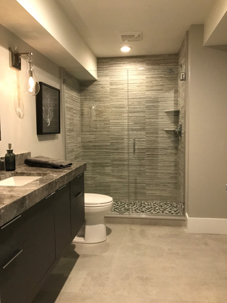На фото: главная ванная комната среднего размера в стиле модернизм с плоскими фасадами, серыми фасадами, двойным душем, раздельным унитазом, серой плиткой, удлиненной плиткой, белыми стенами, полом из керамической плитки, врезной раковиной, мраморной столешницей, серым полом, душем с распашными дверями, серой столешницей, тумбой под одну раковину и подвесной тумбой