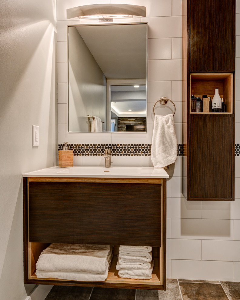 Small trendy 3/4 white tile and ceramic tile ceramic tile walk-in shower photo in Los Angeles with flat-panel cabinets, medium tone wood cabinets, a one-piece toilet, white walls, an integrated sink and solid surface countertops