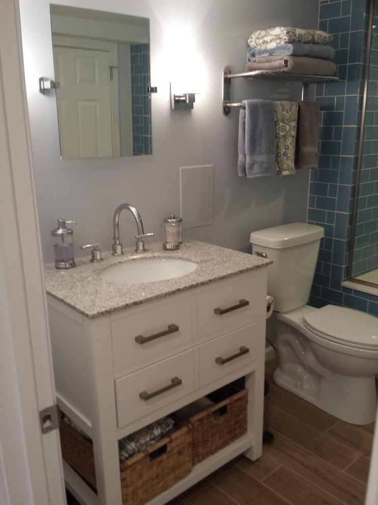 Small trendy 3/4 blue tile and glass tile porcelain tile alcove shower photo in St Louis with white cabinets, granite countertops, a two-piece toilet, flat-panel cabinets, blue walls and an undermount sink