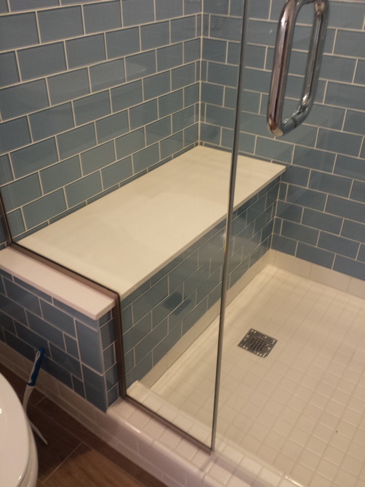 Immagine di una piccola stanza da bagno minimal con piastrelle blu, doccia alcova, piastrelle diamantate, pavimento marrone e porta doccia a battente