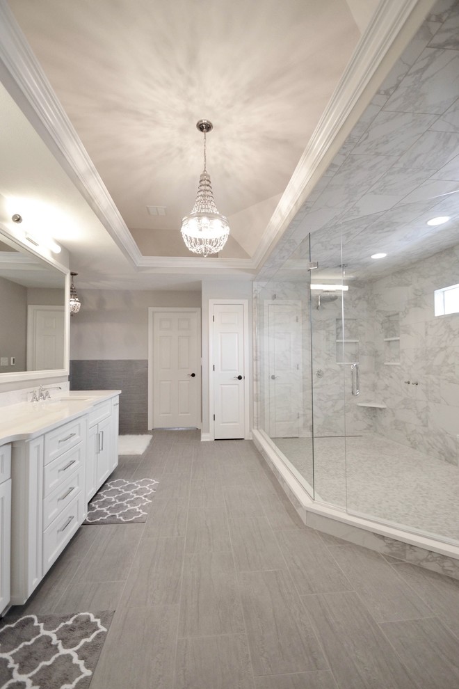 На фото: большая главная ванная комната в стиле модернизм с фасадами в стиле шейкер, белыми фасадами, отдельно стоящей ванной, двойным душем и серыми стенами с