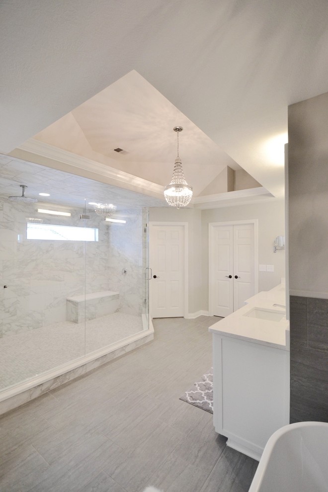 Bild på ett stort funkis en-suite badrum, med vita skåp, ett fristående badkar, en dubbeldusch och grå väggar