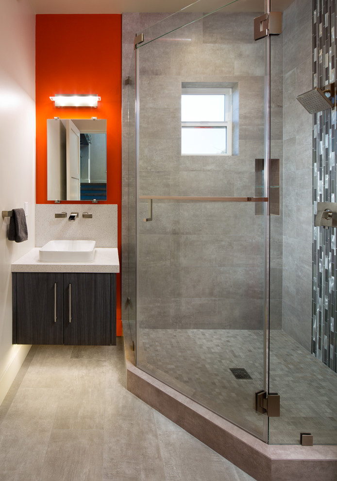 Modelo de cuarto de baño moderno pequeño con ducha esquinera, aseo y ducha, puertas de armario de madera en tonos medios y paredes multicolor