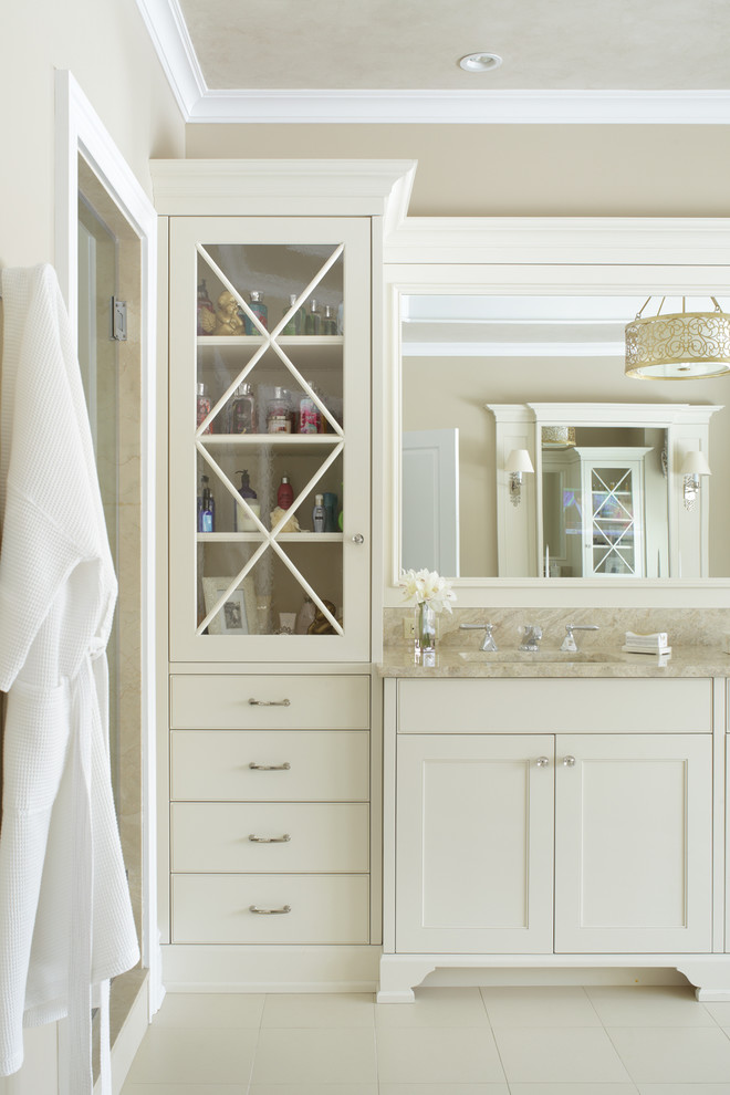 Bild på ett stort vintage en-suite badrum, med luckor med infälld panel, vita skåp, ett fristående badkar, beige väggar, kalkstensgolv, ett undermonterad handfat och granitbänkskiva