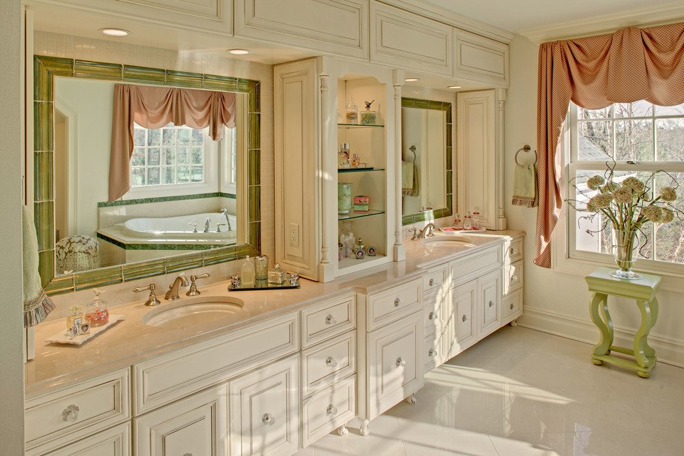 Ispirazione per un'ampia stanza da bagno tradizionale con lavabo sottopiano, ante con bugna sagomata, ante bianche, vasca ad angolo e doccia doppia