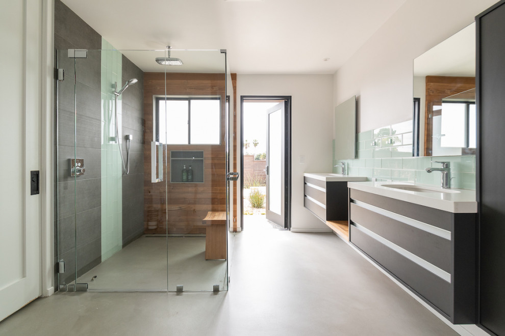Contemporary ensuite bathroom in San Diego with flat-panel cabinets, black cabinets, a built-in shower, grey tiles, green tiles, white walls, concrete flooring, a submerged sink, grey floors, a hinged door, white worktops, a wall niche, a shower bench, double sinks and a floating vanity unit.