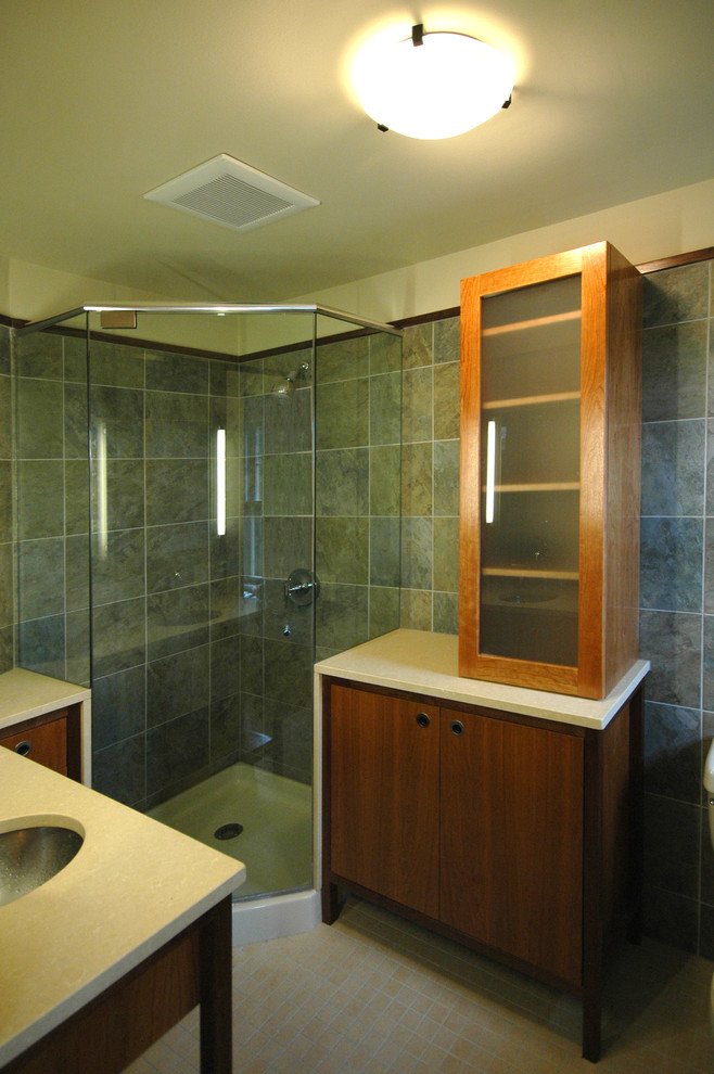Photo of a small contemporary bathroom in Kansas City with a submerged sink, flat-panel cabinets, medium wood cabinets, engineered stone worktops, a corner shower, a two-piece toilet, blue tiles, porcelain tiles, yellow walls and porcelain flooring.