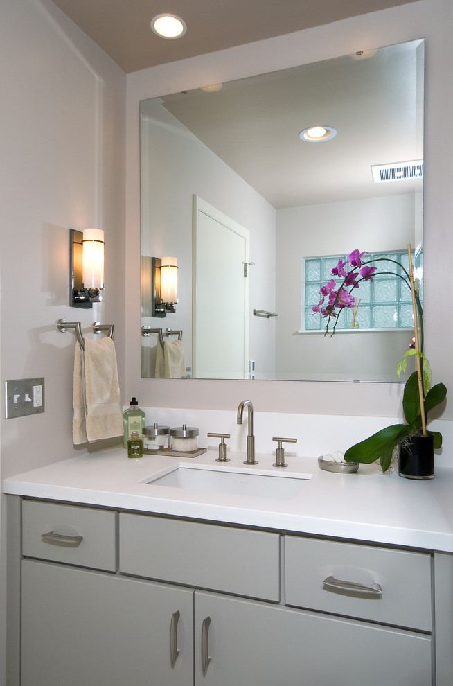 Ejemplo de cuarto de baño actual con lavabo bajoencimera, ducha empotrada, sanitario de dos piezas, paredes blancas y suelo de baldosas de cerámica