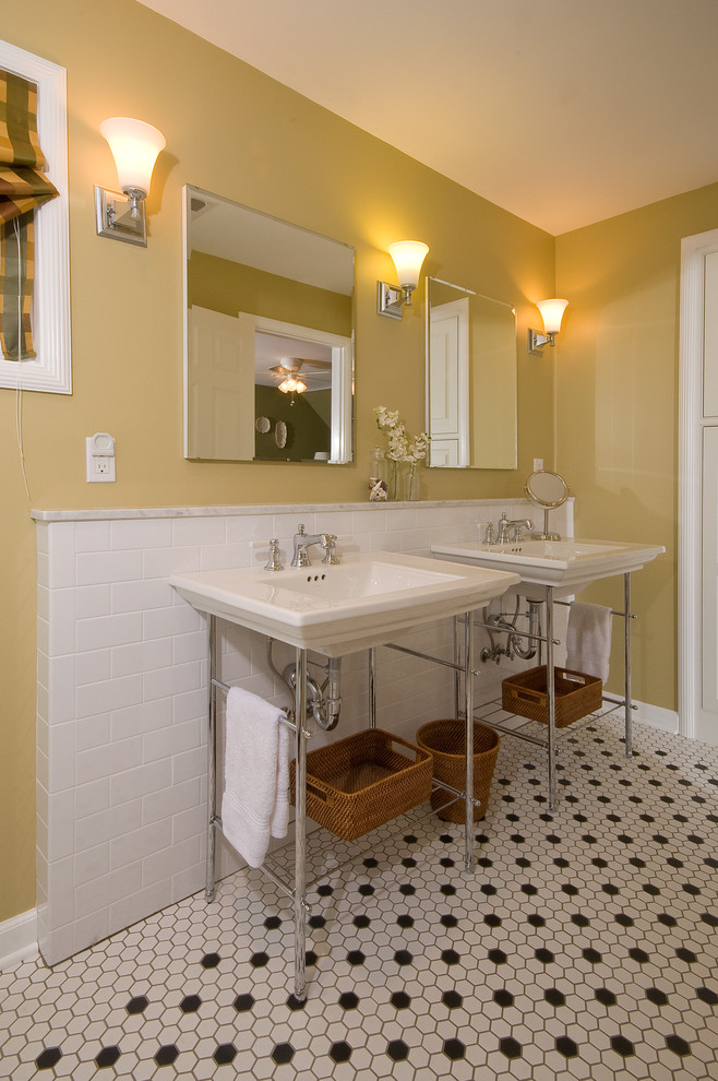 Bild på ett vintage en-suite badrum, med ett konsol handfat, gula väggar, vit kakel, en toalettstol med separat cisternkåpa och en dusch i en alkov