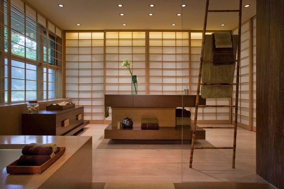 Exemple d'une salle de bain asiatique en bois foncé avec une baignoire encastrée et un carrelage beige.