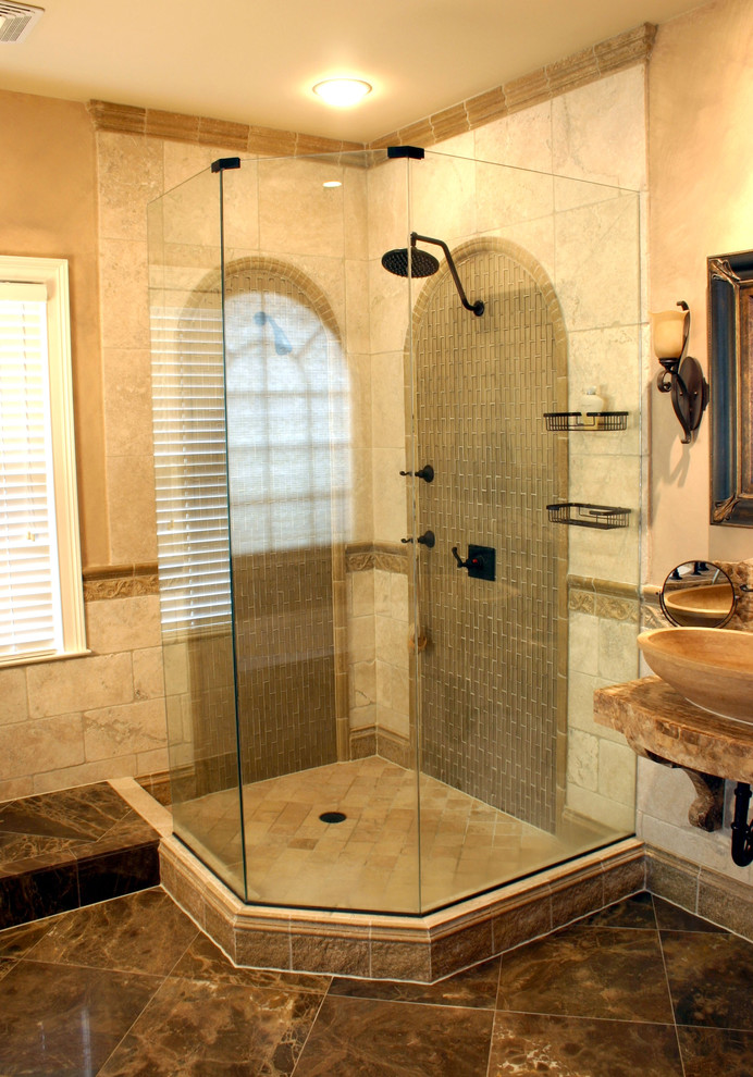 Imagen de cuarto de baño mediterráneo con ducha esquinera, lavabo sobreencimera, suelo marrón, baldosas y/o azulejos de travertino y piedra