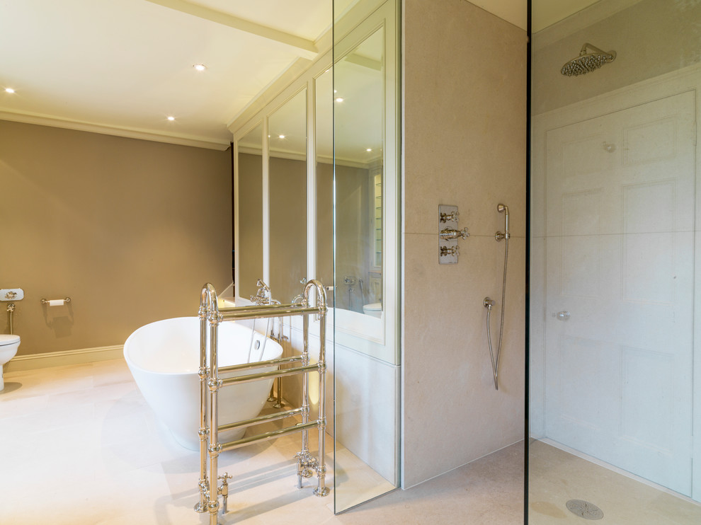 Inspiration for a large traditional ensuite bathroom in Other with a submerged sink, raised-panel cabinets, green cabinets, marble worktops, a freestanding bath, a one-piece toilet, brown walls and limestone flooring.