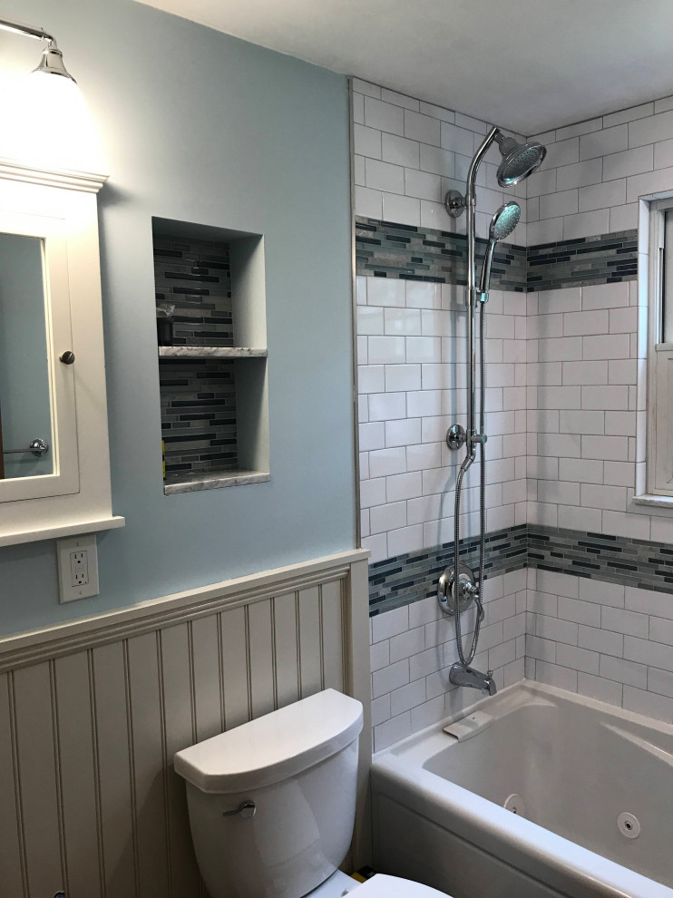 Идея дизайна: ванная комната среднего размера в стиле модернизм с фасадами в стиле шейкер, белыми фасадами, гидромассажной ванной, душем над ванной, раздельным унитазом, белой плиткой, керамической плиткой, синими стенами, полом из керамической плитки, врезной раковиной, мраморной столешницей, серым полом, шторкой для ванной, белой столешницей, нишей, тумбой под одну раковину, встроенной тумбой и панелями на стенах