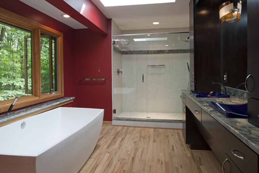Источник вдохновения для домашнего уюта: большая главная ванная комната в классическом стиле с темными деревянными фасадами, отдельно стоящей ванной, душем в нише, красными стенами, паркетным полом среднего тона, накладной раковиной и столешницей из гранита
