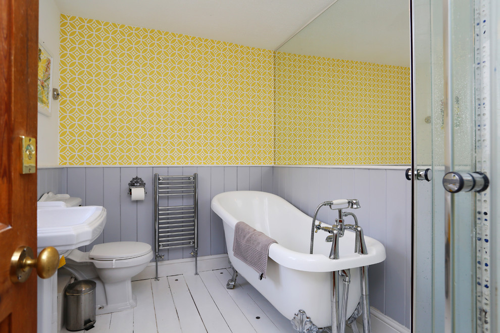 Inspiration för ett mellanstort eklektiskt badrum för barn, med ett badkar med tassar, en hörndusch, en toalettstol med separat cisternkåpa, gula väggar, målat trägolv, ett piedestal handfat, vitt golv och dusch med gångjärnsdörr