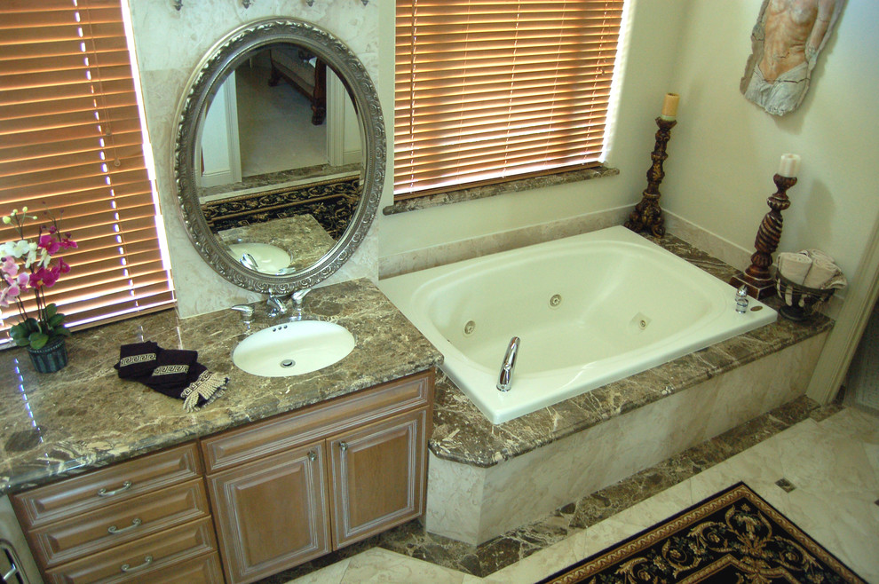 Aménagement d'une grande salle de bain principale classique en bois clair avec un lavabo encastré, un placard avec porte à panneau surélevé, un plan de toilette en marbre, un carrelage beige, un mur beige, un sol en marbre, un sol beige, WC séparés et une baignoire posée.