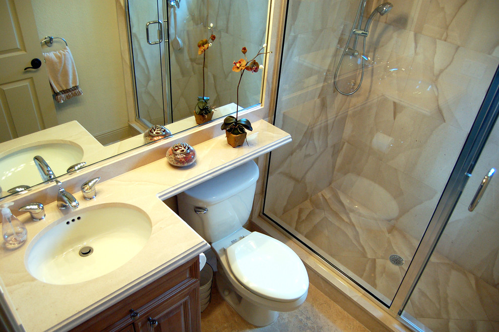 Cette image montre une petite salle d'eau traditionnelle en bois brun avec un lavabo encastré, un placard avec porte à panneau surélevé, un mur beige, un espace douche bain, WC séparés, un carrelage beige, un sol en marbre, un plan de toilette en quartz modifié, un sol beige et une cabine de douche à porte battante.
