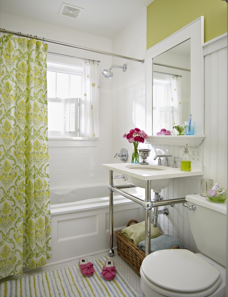 Klassisches Badezimmer mit Unterbauwaschbecken, Einbaubadewanne, Wandtoilette mit Spülkasten, weißen Fliesen und grüner Wandfarbe in Sonstige