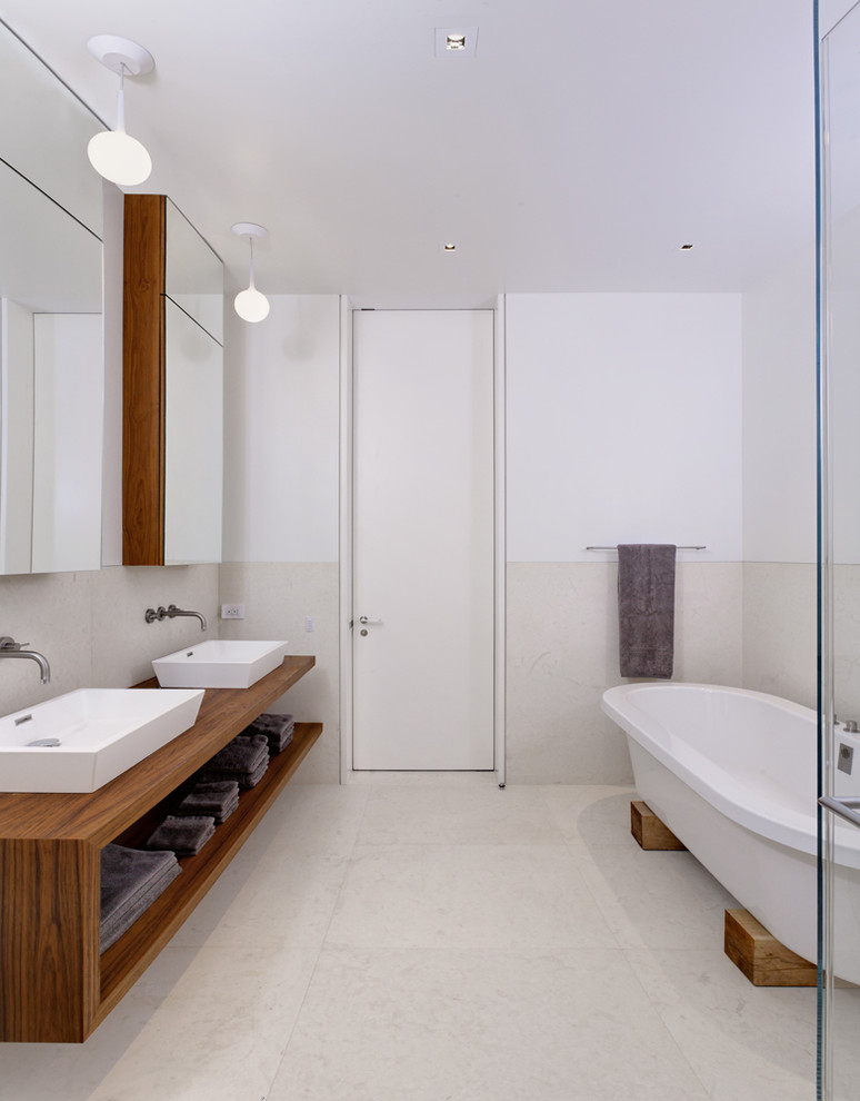 Пример оригинального дизайна: ванная комната в современном стиле с настольной раковиной, открытыми фасадами и отдельно стоящей ванной