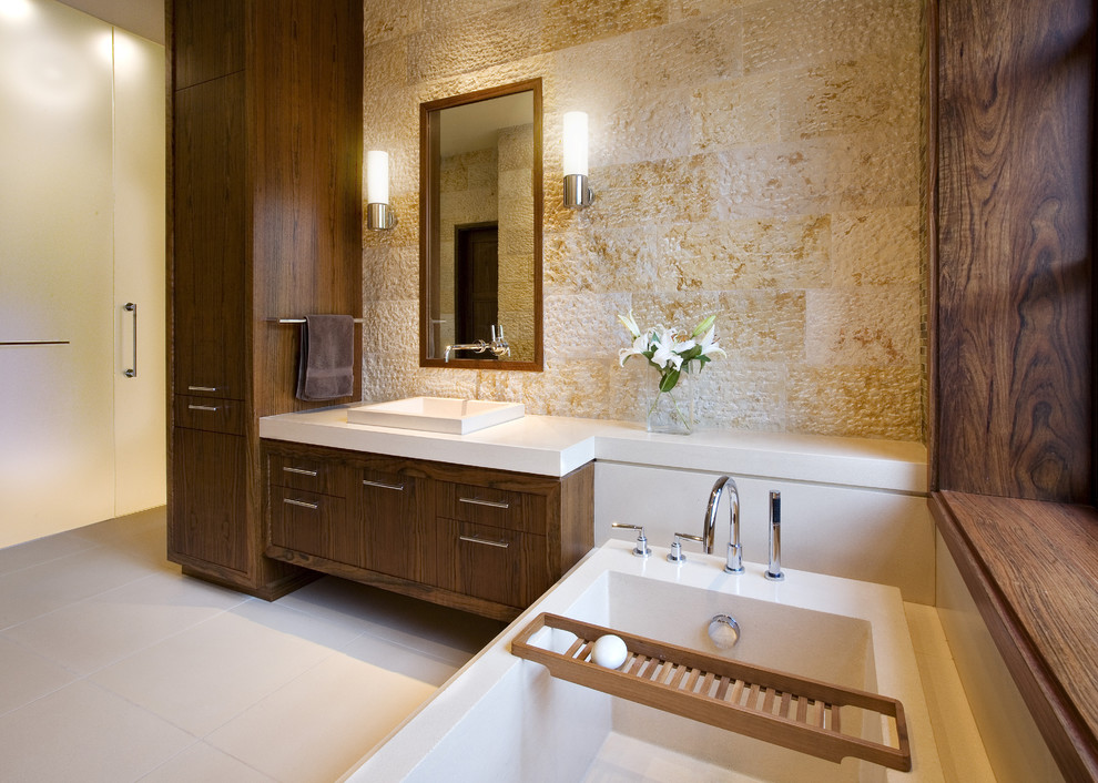 Inspiration pour une grande salle de bain principale minimaliste en bois brun avec un placard à porte plane, une baignoire posée, un mur beige et une vasque.