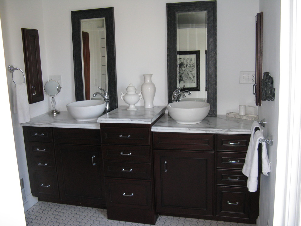 Foto di una stanza da bagno tradizionale di medie dimensioni con lavabo a bacinella, ante con bugna sagomata, ante in legno bruno e top in laminato