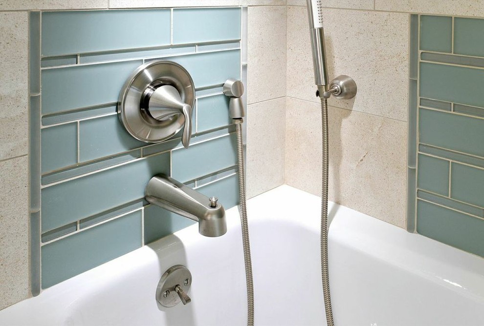 Ispirazione per una stanza da bagno design con vasca/doccia, piastrelle blu e piastrelle di vetro