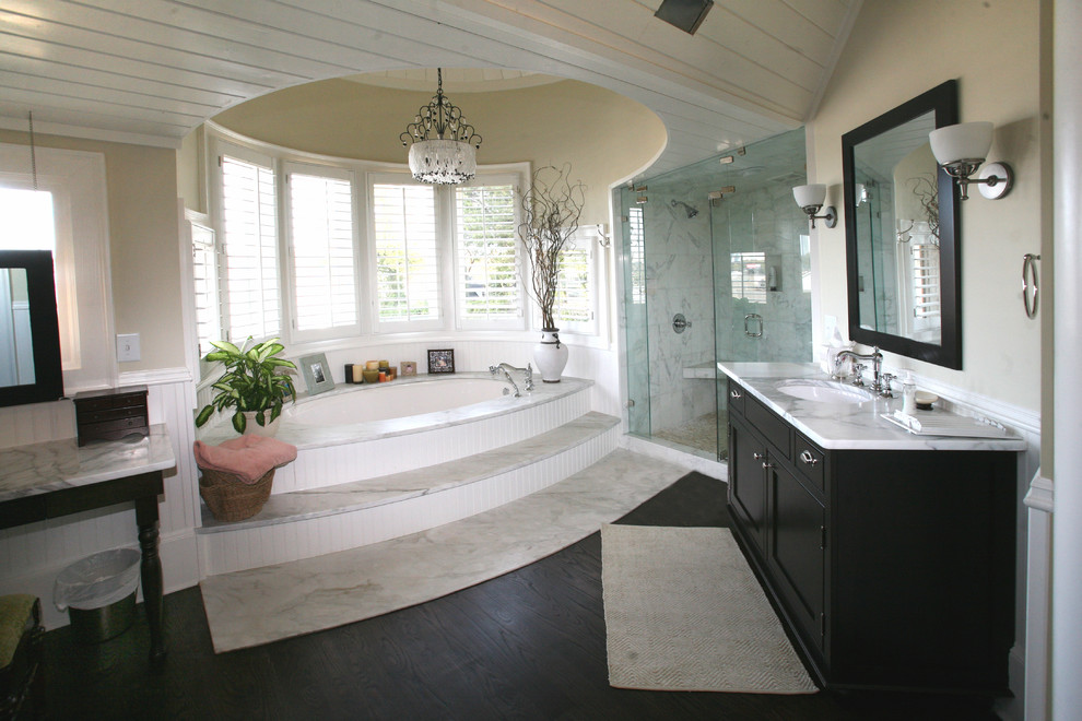 Ispirazione per una stanza da bagno classica con lavabo sottopiano, ante con riquadro incassato, ante nere, doccia alcova e vasca sottopiano