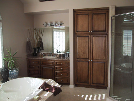 This is an example of a medium sized traditional ensuite bathroom in San Diego with raised-panel cabinets, dark wood cabinets, a built-in bath, a corner shower, beige tiles, black and white tiles, blue tiles, stone slabs, beige walls, travertine flooring, a submerged sink, granite worktops and beige floors.