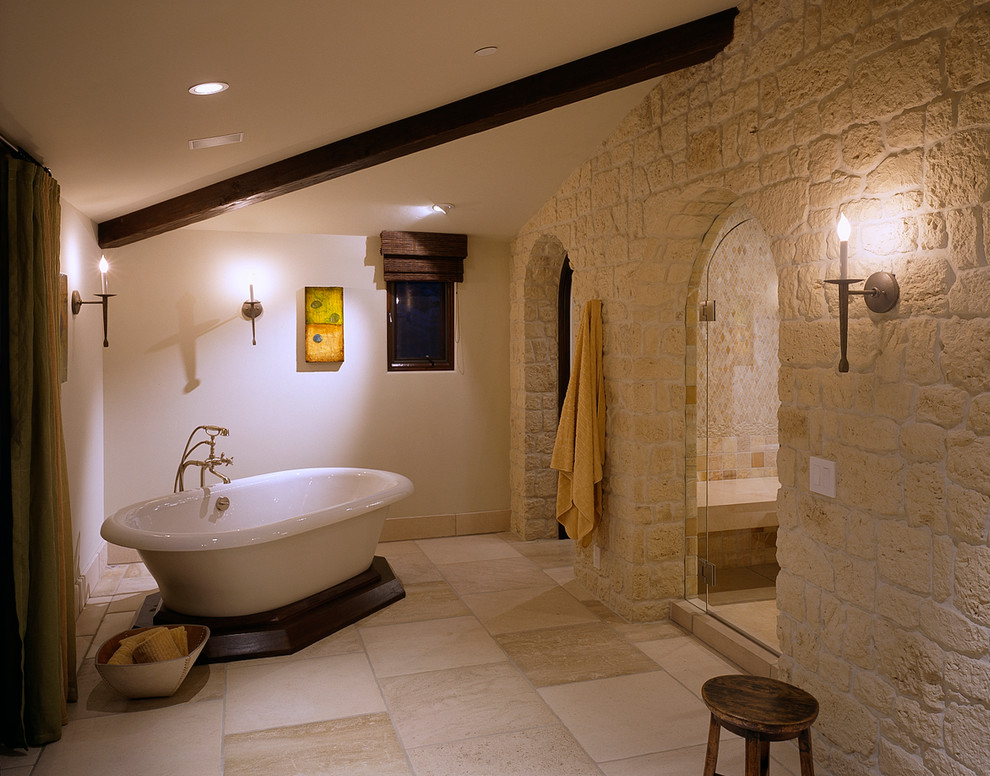 Ejemplo de cuarto de baño tradicional con bañera exenta y piedra