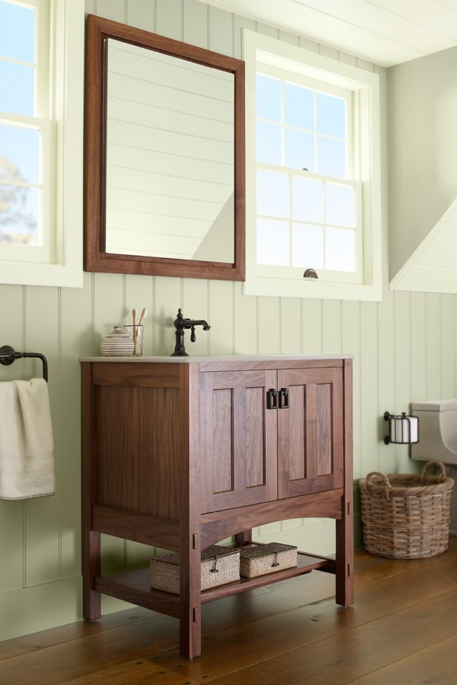 Inspiration pour une salle d'eau rustique en bois brun de taille moyenne avec un lavabo encastré, un placard à porte affleurante, WC à poser, un mur vert, un sol en bois brun et un plan de toilette en surface solide.