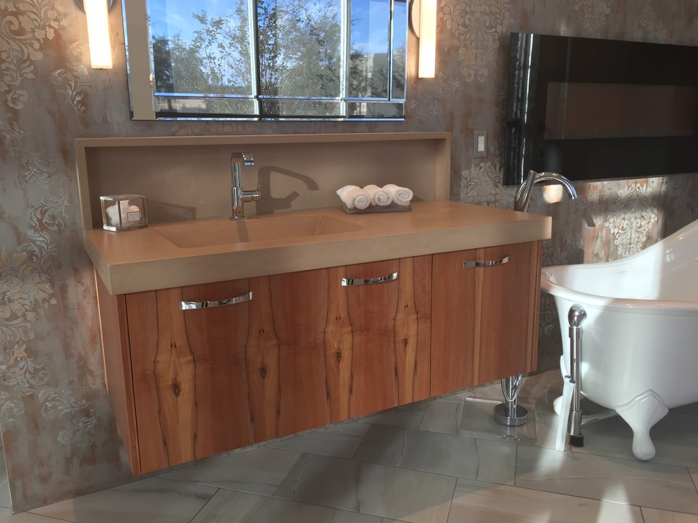 Idée de décoration pour une grande salle de bain principale design en bois brun avec un placard à porte plane, une baignoire sur pieds, un mur beige, un lavabo intégré, un plan de toilette en béton et un sol en carrelage de porcelaine.