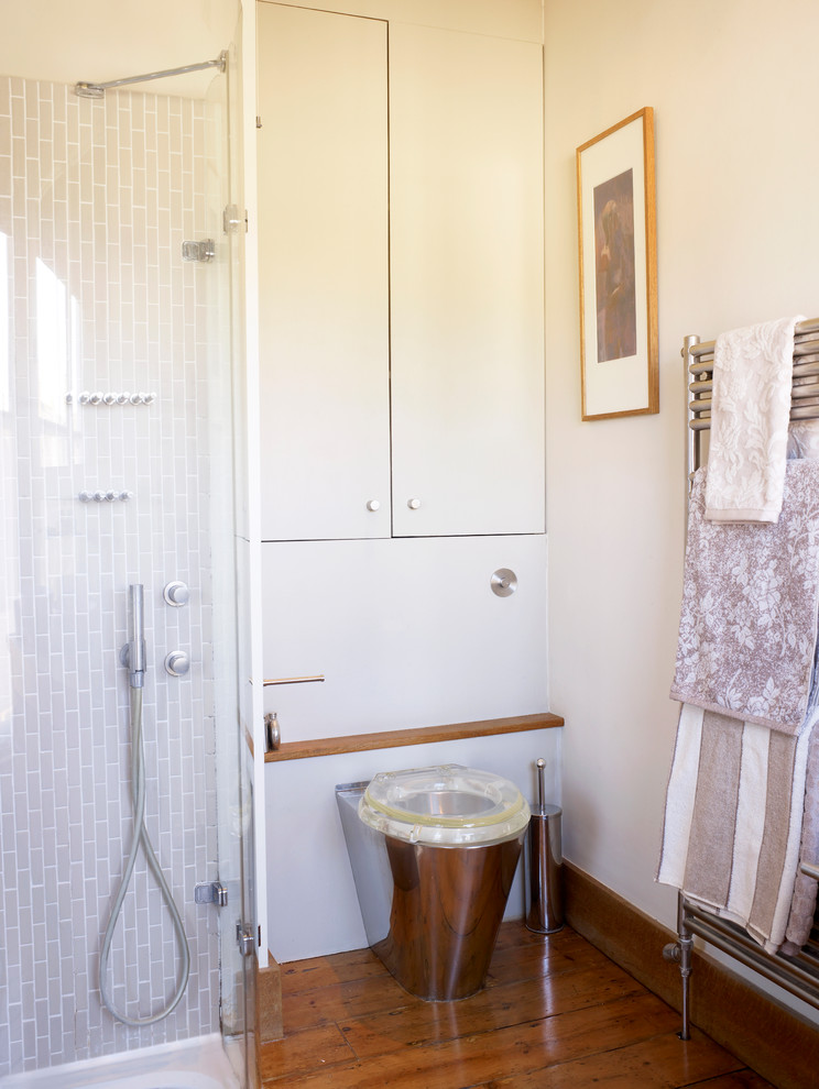 Ispirazione per una stanza da bagno padronale design di medie dimensioni con doccia ad angolo, WC monopezzo, piastrelle beige, pareti beige e pavimento in legno massello medio