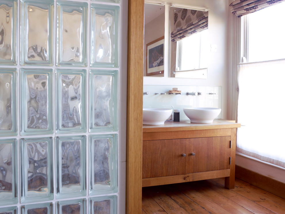 Idéer för mellanstora funkis en-suite badrum, med ett fristående handfat, ett fristående badkar, beige väggar och mellanmörkt trägolv