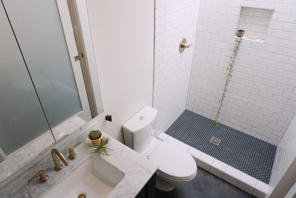 Immagine di una piccola stanza da bagno moderna con doccia alcova, WC monopezzo, pistrelle in bianco e nero, piastrelle in ceramica, pareti bianche, pavimento in cemento, lavabo sottopiano, pavimento nero e doccia con tenda