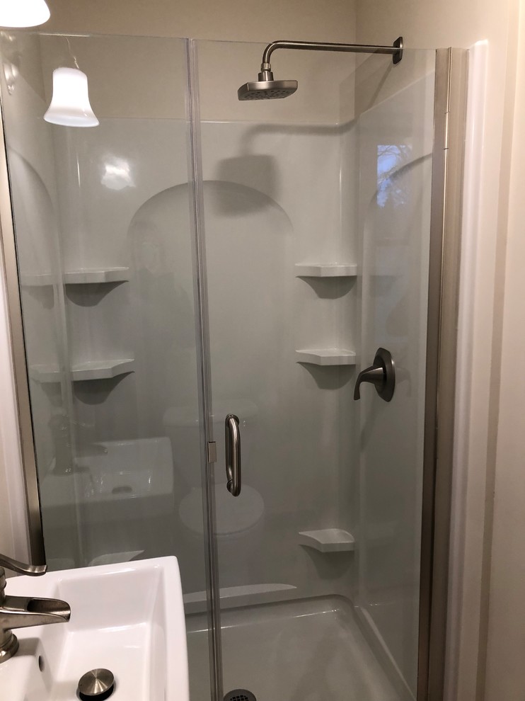 Modelo de cuarto de baño minimalista pequeño con puertas de armario con efecto envejecido, ducha abierta, paredes beige, suelo laminado, encimera de mármol, suelo marrón, ducha con puerta con bisagras y encimeras blancas