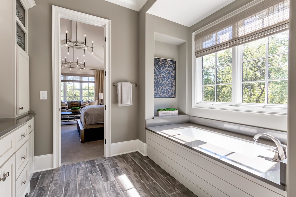 Large classic ensuite bathroom in Nashville with recessed-panel cabinets, white cabinets, a freestanding bath, an alcove shower, a two-piece toilet, beige walls, ceramic flooring, a submerged sink, granite worktops, brown floors and a hinged door.